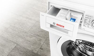 Eine Hand zieht den Garbehälter einer digitalen Heißluftfritteuse mit Display bei 180°C und 20 Minuten heraus.